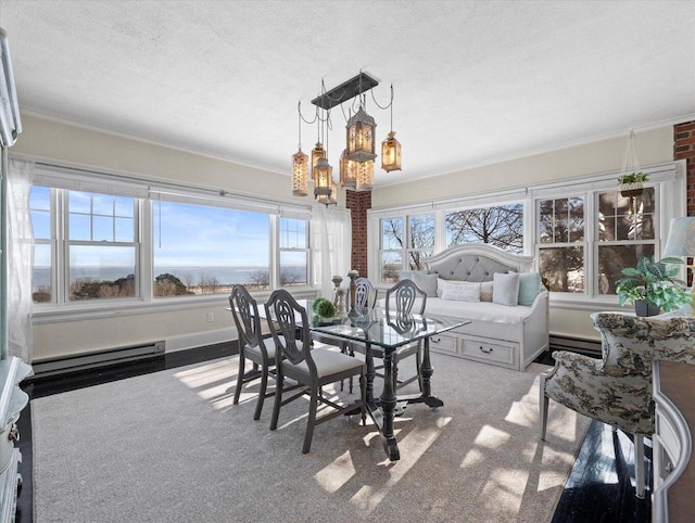 sunroom featuring a chandelier and a baseboard heating unit