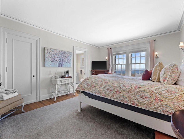 bedroom featuring ornamental molding and dark wood-type flooring