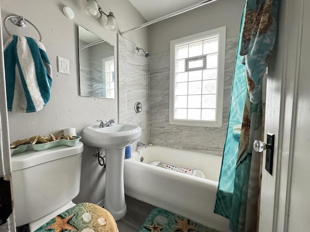 bathroom featuring shower / tub combo with curtain and toilet