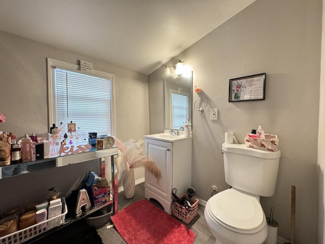 bathroom with vanity, toilet, and vaulted ceiling