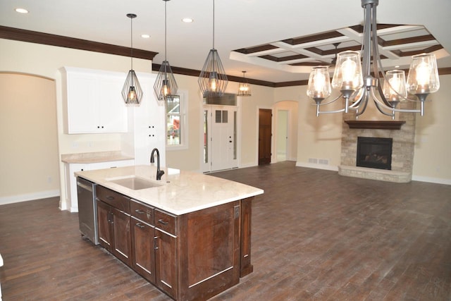 kitchen with sink, coffered ceiling, beamed ceiling, pendant lighting, and a fireplace