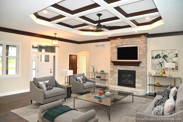 living room with coffered ceiling, a stone fireplace, beamed ceiling, hardwood / wood-style floors, and ornamental molding