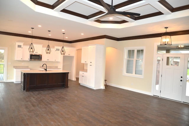 kitchen featuring white cabinetry, an island with sink, hanging light fixtures, and coffered ceiling