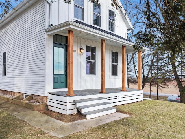 property entrance featuring covered porch and a yard