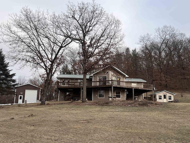 view of property featuring an outbuilding, a front yard, a garage, and a wooden deck