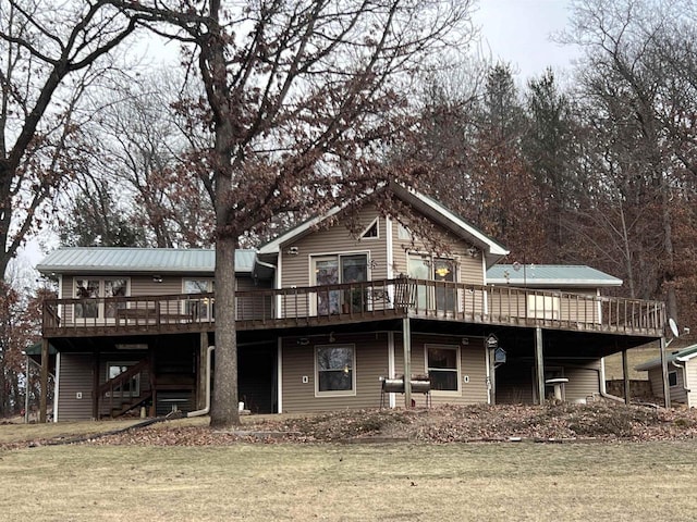 rear view of property with a lawn and a deck