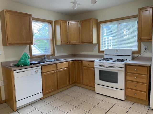 kitchen featuring sink, light tile patterned floors, and white appliances