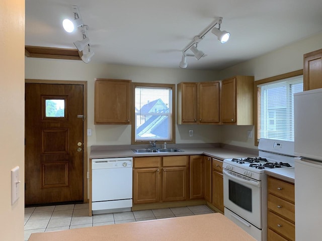 kitchen with light tile patterned floors, white appliances, and sink