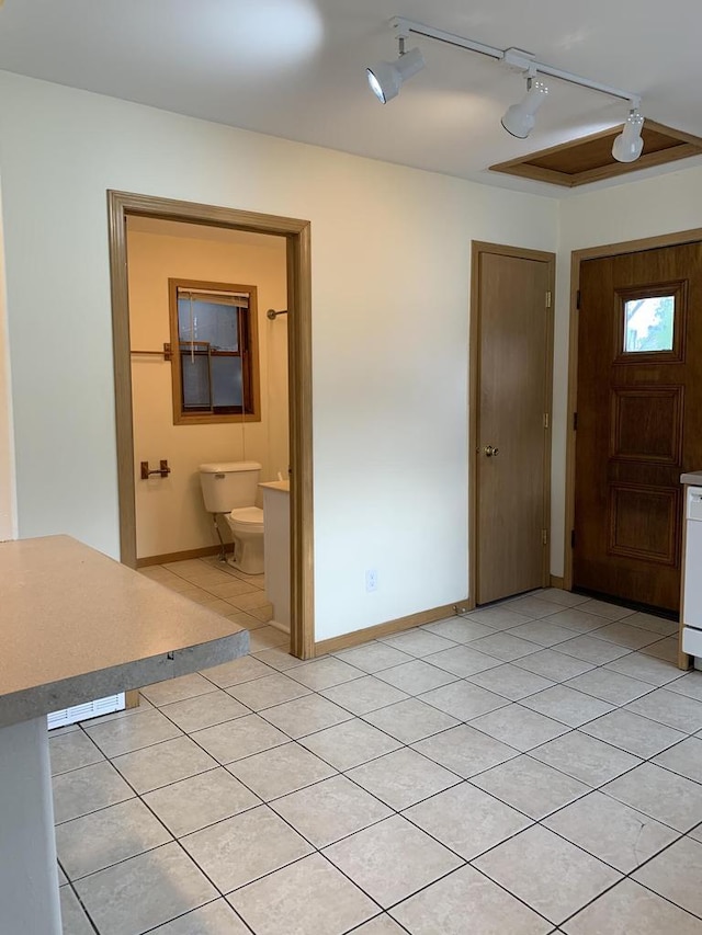 foyer featuring rail lighting and light tile patterned flooring