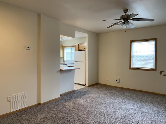 carpeted spare room with ceiling fan