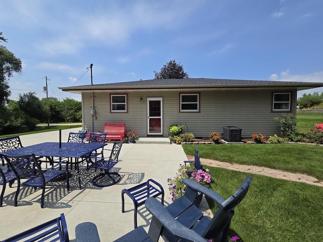 rear view of house with cooling unit, a yard, and a patio