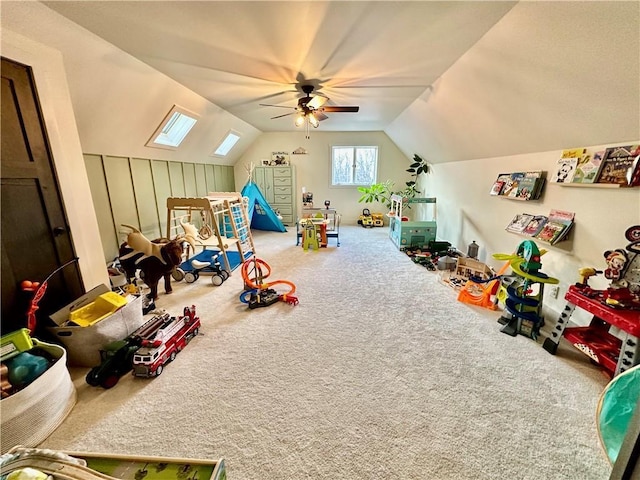 game room with carpet floors, lofted ceiling with skylight, and ceiling fan