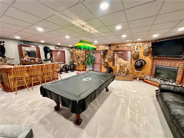 rec room with wooden walls, carpet, indoor bar, and pool table