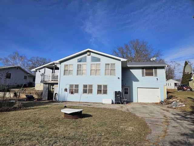 back of property with a lawn and a garage