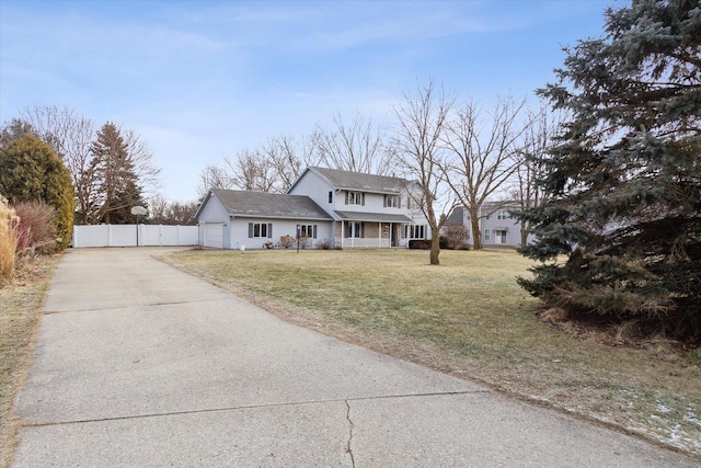 view of front of house featuring a porch, a garage, and a front lawn