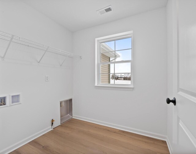 laundry area with washer hookup and light hardwood / wood-style floors