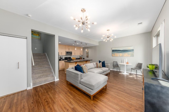 living room featuring light wood-type flooring and a notable chandelier