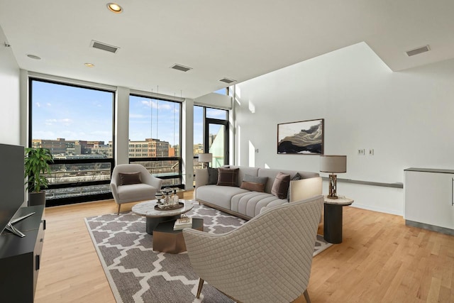 living room with floor to ceiling windows and light hardwood / wood-style floors