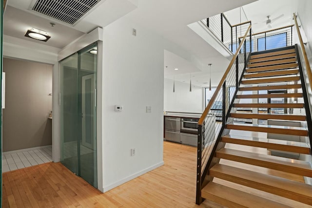 staircase featuring wood-type flooring and a wealth of natural light