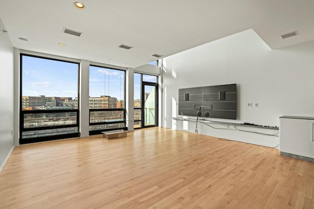 unfurnished living room featuring expansive windows and light wood-type flooring