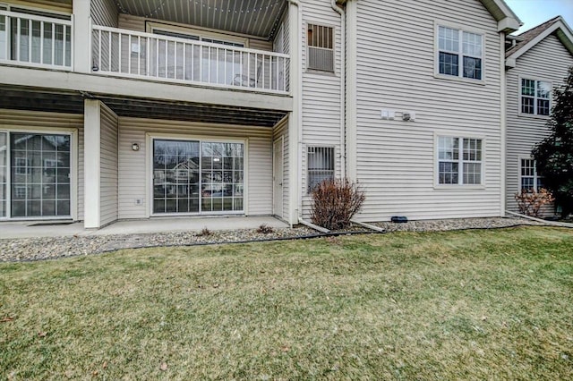 view of side of home featuring a balcony and a lawn