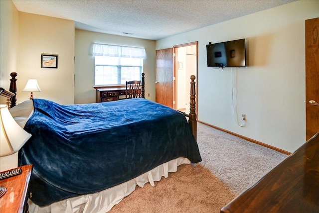 bedroom with a textured ceiling and light colored carpet