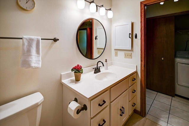 bathroom with toilet, washer / dryer, vanity, and tile patterned floors