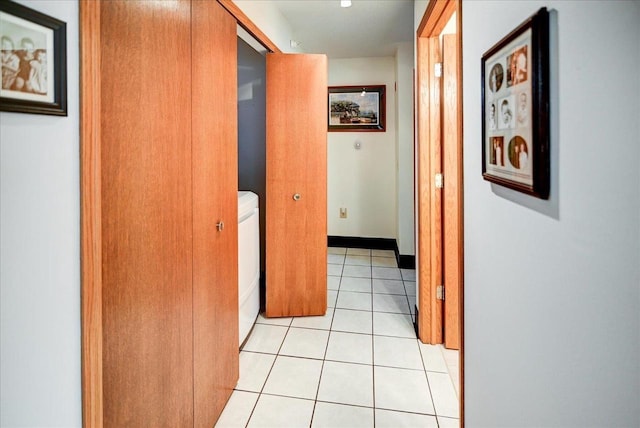 corridor featuring washer / dryer and light tile patterned floors