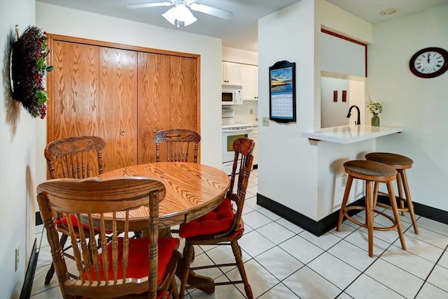 tiled dining area featuring ceiling fan