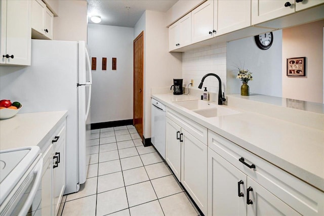 kitchen featuring stove, white dishwasher, sink, decorative backsplash, and white cabinetry