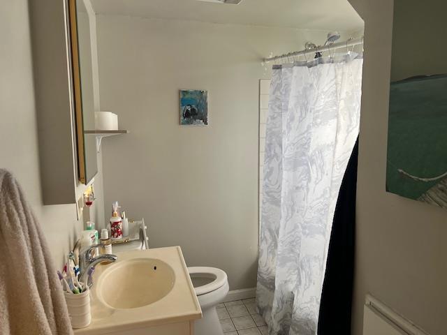 bathroom featuring tile patterned flooring, vanity, toilet, and a shower with shower curtain