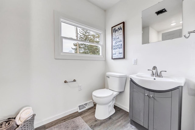 bathroom with wood-type flooring, vanity, and toilet