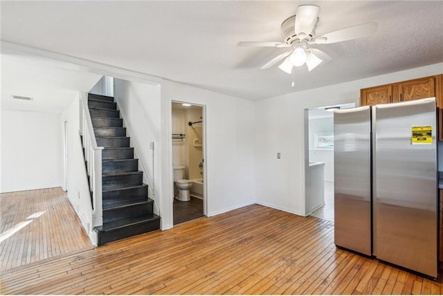 kitchen featuring ceiling fan, light wood-type flooring, and stainless steel refrigerator