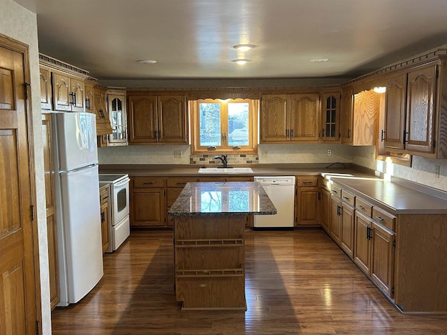 kitchen featuring a center island, dark wood-type flooring, white appliances, and sink