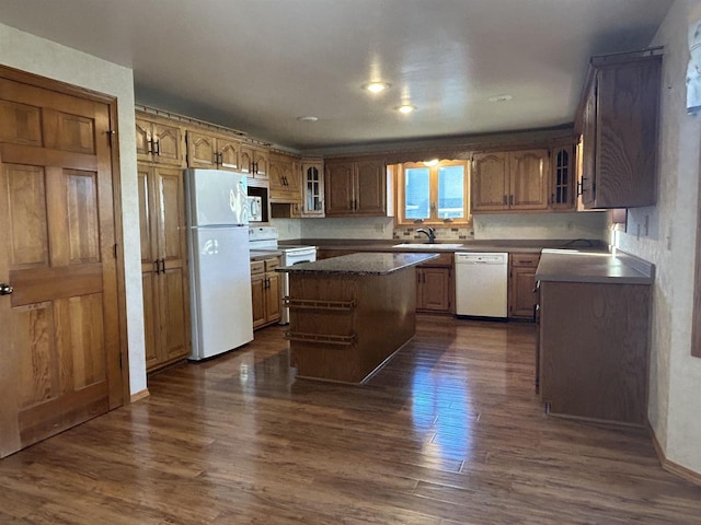 kitchen with dark hardwood / wood-style flooring, white appliances, a center island, and sink