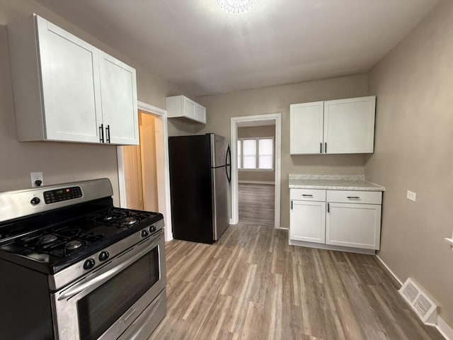 kitchen featuring white cabinetry, light hardwood / wood-style floors, and appliances with stainless steel finishes