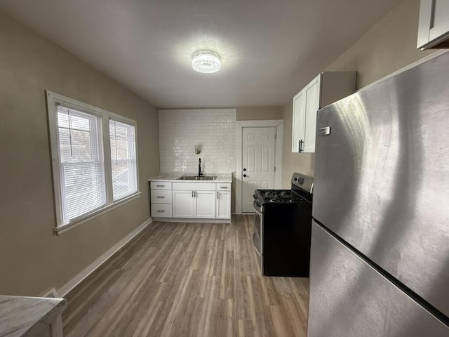 kitchen featuring white cabinets, light hardwood / wood-style floors, sink, and appliances with stainless steel finishes