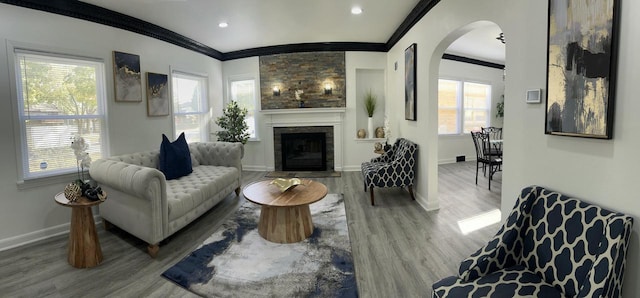 living room featuring a fireplace, wood-type flooring, and ornamental molding