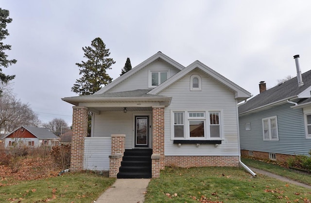 bungalow-style house featuring a porch and a front yard