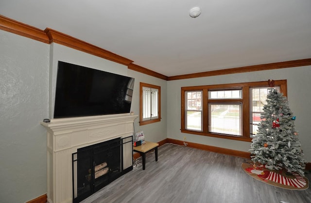 unfurnished living room with hardwood / wood-style floors and crown molding