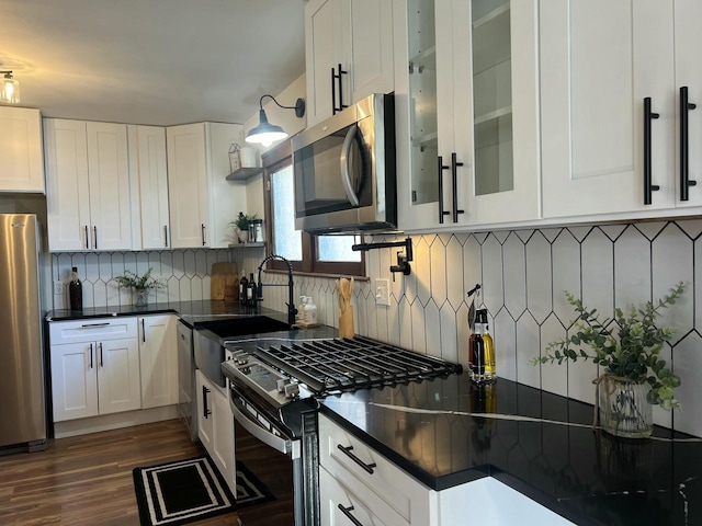 kitchen featuring white cabinets, dark hardwood / wood-style flooring, stainless steel appliances, and tasteful backsplash