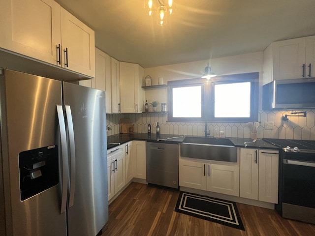 kitchen with tasteful backsplash, sink, white cabinets, and appliances with stainless steel finishes