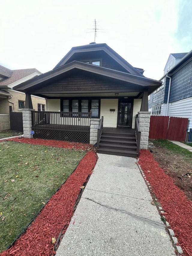 view of front of property featuring covered porch and a front lawn