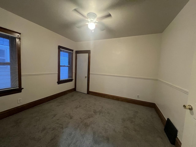 carpeted spare room featuring ceiling fan