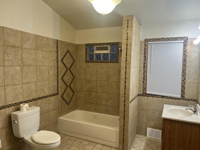 full bathroom with toilet, vanity, tile patterned floors, and tile walls