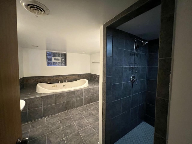 bathroom with tile patterned flooring and tiled shower