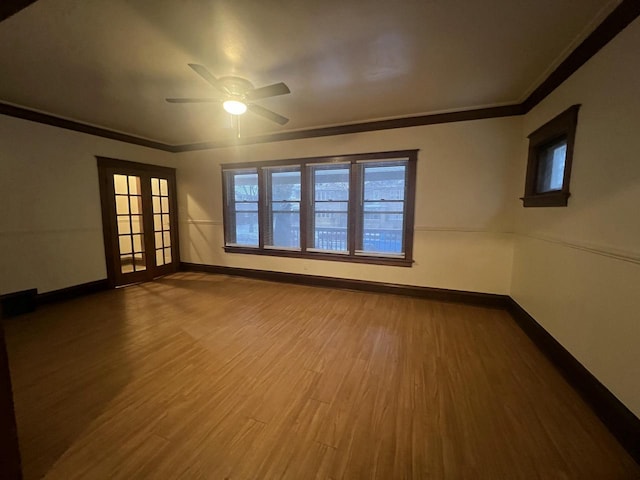 empty room featuring crown molding, french doors, ceiling fan, and wood-type flooring