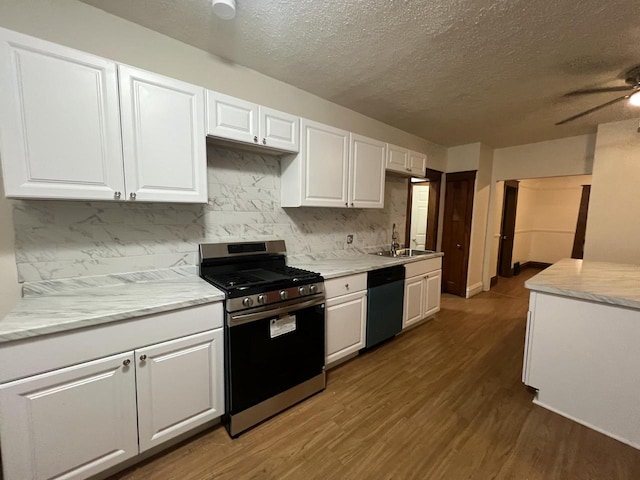 kitchen with stainless steel range with gas cooktop, sink, a textured ceiling, black dishwasher, and white cabinetry