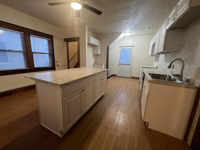 kitchen with white cabinetry, sink, dark hardwood / wood-style floors, backsplash, and a textured ceiling