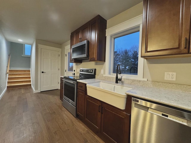 kitchen featuring dark hardwood / wood-style flooring, dark brown cabinetry, sink, and appliances with stainless steel finishes